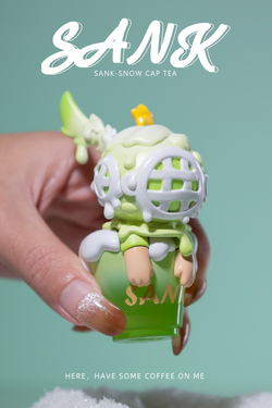 A hand holding a small Sank-Snow cap tea toy, a white letter on blue background, a green dinosaur toy, and a close-up of the toy. Preorder - Ships July 2024. Limited Edition: 199 Sets. Materials: Resin.