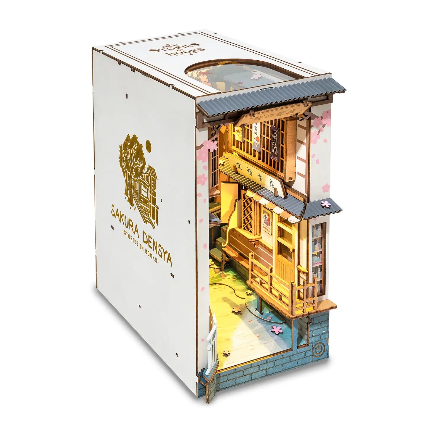 A white book nook kit featuring a Sakura Tram design, with a small house inside, wooden box, and intricate details. Dimensions: 9.4 x 3.9 x 7.4 in (23.9 x 9.9 x 18.8 cm).