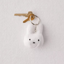 A Miffy plush keychain, designed in the Netherlands. Features a white stuffed rabbit on a keychain. Perfect for art toy enthusiasts from Strangecat Toys.