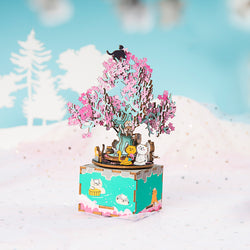 A DIY Music Box Cherry Blossom Tree with cat and flower figurines. Hand-cranked for a classic melody experience. Enhance focus and relaxation with this intricate, thoughtful design. From Strangecat Toys.