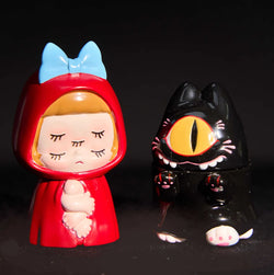 A close-up of a toy figurine from the Abao Magic Memi & Ghost Kiiti series by Abao, featuring a red doll, a black cat statue, and a girl with a cat.