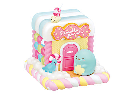 A blind box series featuring Sumikkogurashi House Of Sweets Re-ment designs, including a toy house with a blue penguin, pink door, bird, animal, fish-shaped cookie, and cartoon whale.