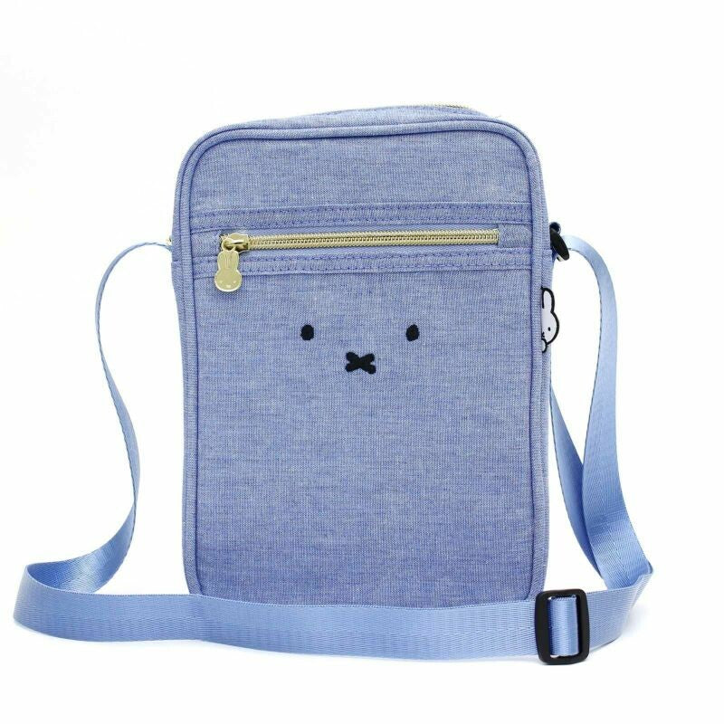 Miffy - Siffler Shoulder Bag Blue, a dungaree fabric vertical shoulder bag with Miffy design details. Adjustable strap for versatile wear. Front pocket fits iPhone Plus. © Mercis bv. Size: W17 x H23 x D6 cm.