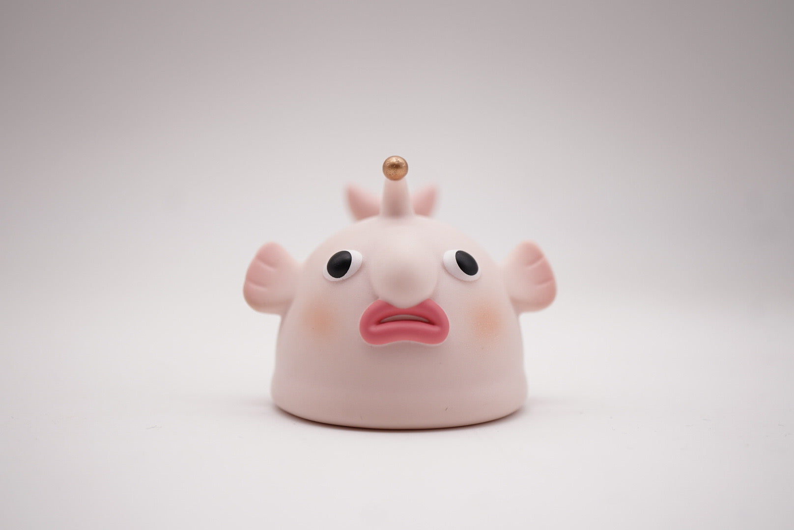 Vinyl toy of POH's Pupu by Vin, an animal figure with a cartoon face and features like a mouth, eyeball, and foot.
