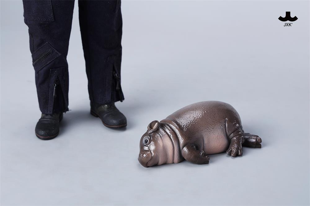 JXK-Baby Hippopotamus Figurine- MooDeng 3 next to legs and boots, showcasing a resin-crafted design, part of Strangecat Toys' limited edition collection.