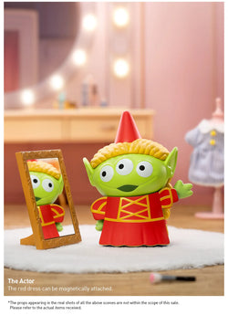 A toy alien in a red dress looking at a mirror, part of the Disney/Pixar Alien-Immersive Experience Blind Box Series.