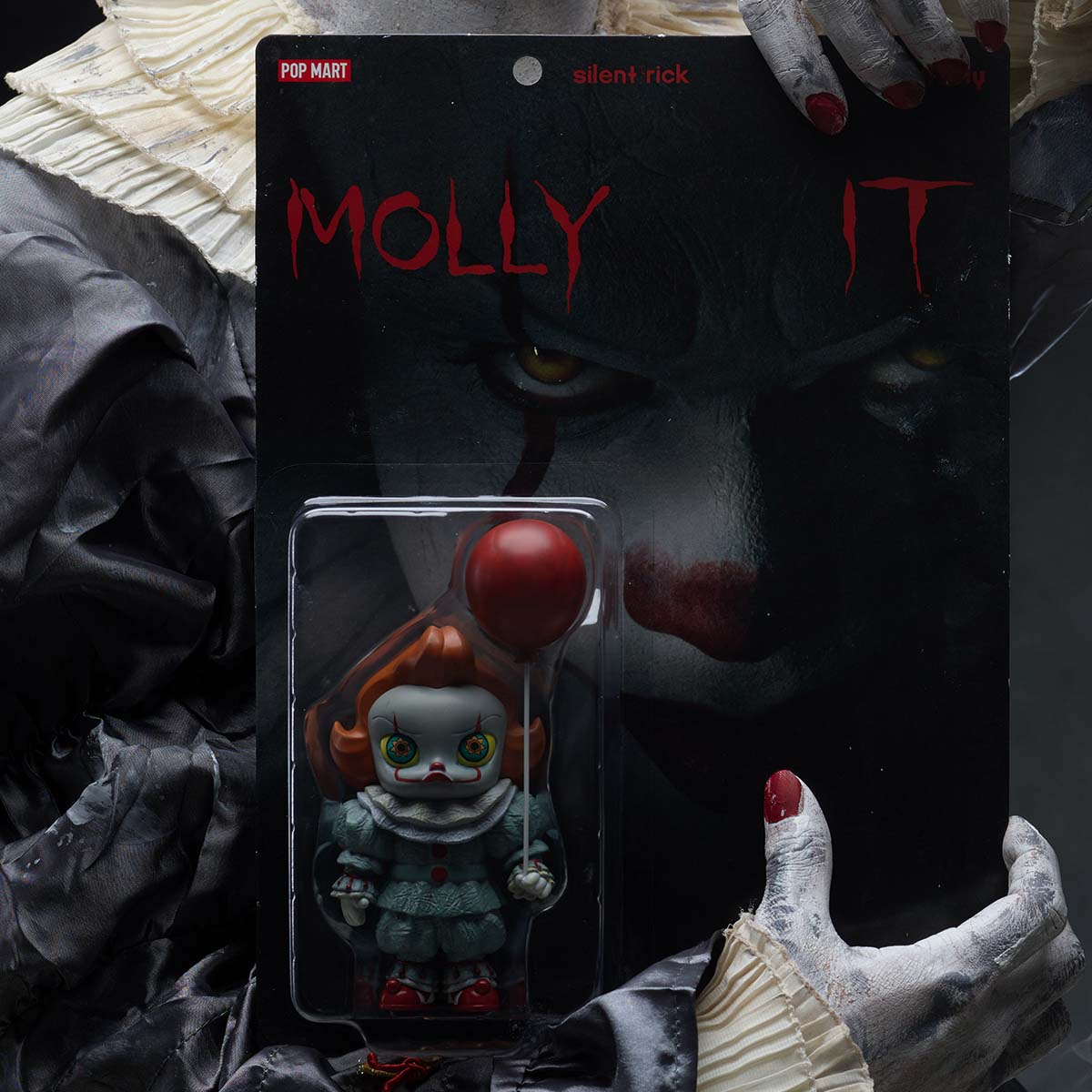 MOLLY - IT Mini figure in packaging, held by a hand; preorder for late Feb 2025, includes a 15cm balloon, made of PVC/Resin/Metals.