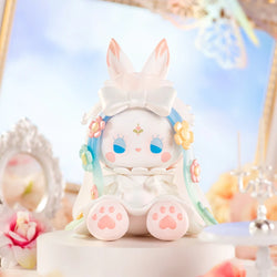 Emma Secret Forest Beloved Blind Box toy, featuring a white animal with blue hair, dressed in a floral dress and bow, part of a collectible series.