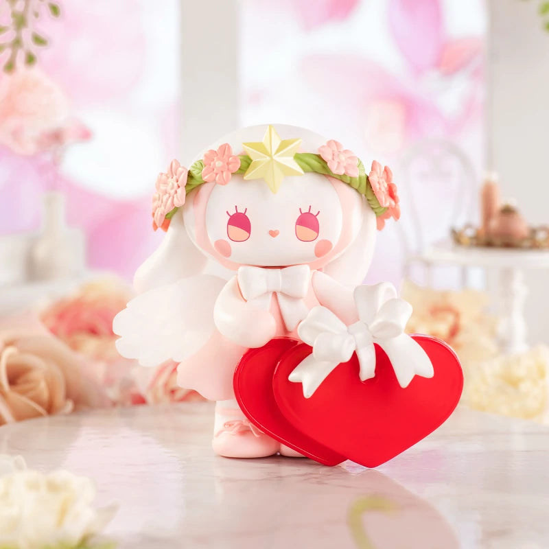 Toy doll from Emma Secret Forest Beloved Blind Box Series, holding a heart-shaped box with a white bow, featuring intricate floral and star details.