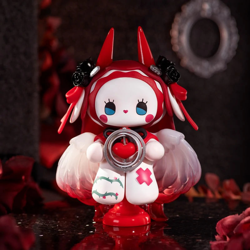 Emma Secret Forest Beloved Blind Box Series toy with wings and red hair, featuring a heart in a metal ring, displayed on a table.