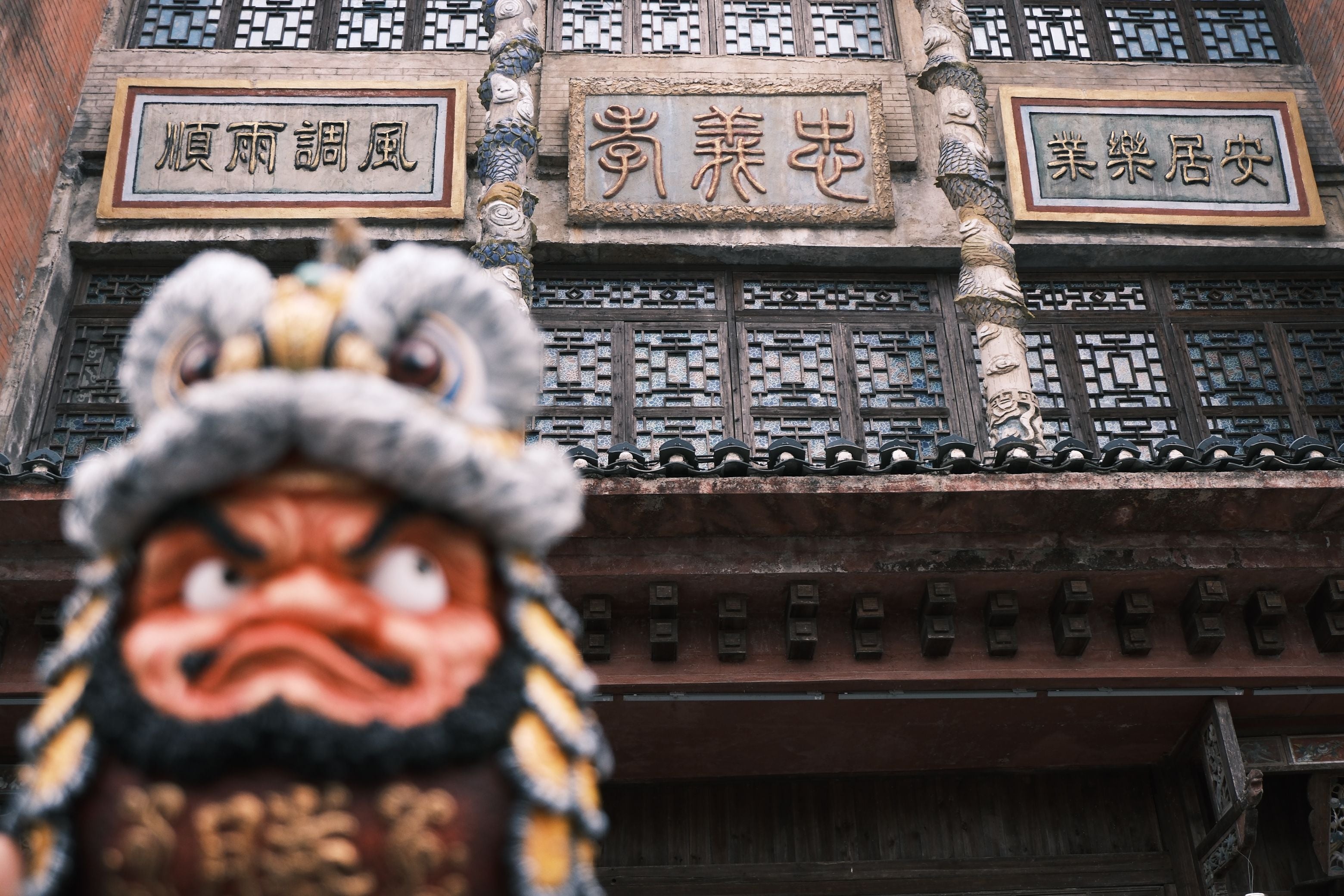 Daruma Doll-Lion Dance-Yellow statue, preorder item, 25cm resin, limited edition of 150, displayed in front of a building with Chinese characters. Ships Q2 2025.