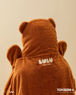 A close-up of LuLu the Piggy Costume Series - Blanket with Hat, featuring a bear garment, fabric, and stuffed elements. Ideal for storing cards and photos. From Strangecat Toys.