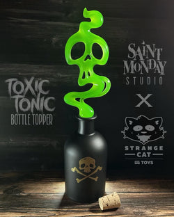 A green plastic skull bottle topper with a skull and crossbones design, glowing in the dark. Perfect for spookifying your favorite bottle. Silicone base for wine safety. Dimensions: 7 1/4” tall, 2 3/4” wide.