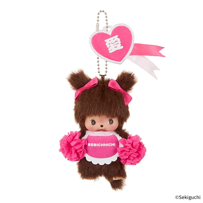 Happy Color Monchhichi Keychain featuring soft fabric, pink bows, heart tag, and pink pom poms, perfect for accessorizing with a playful touch.