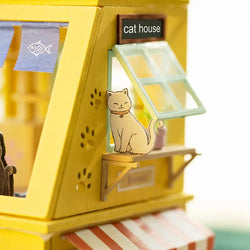 A DIY wooden dollhouse shaped like a cat, featuring three floors for cat activities like eating and playing. Dimensions: 11.4 x 7.7 x 2.8 in. From Strangecat Toys.