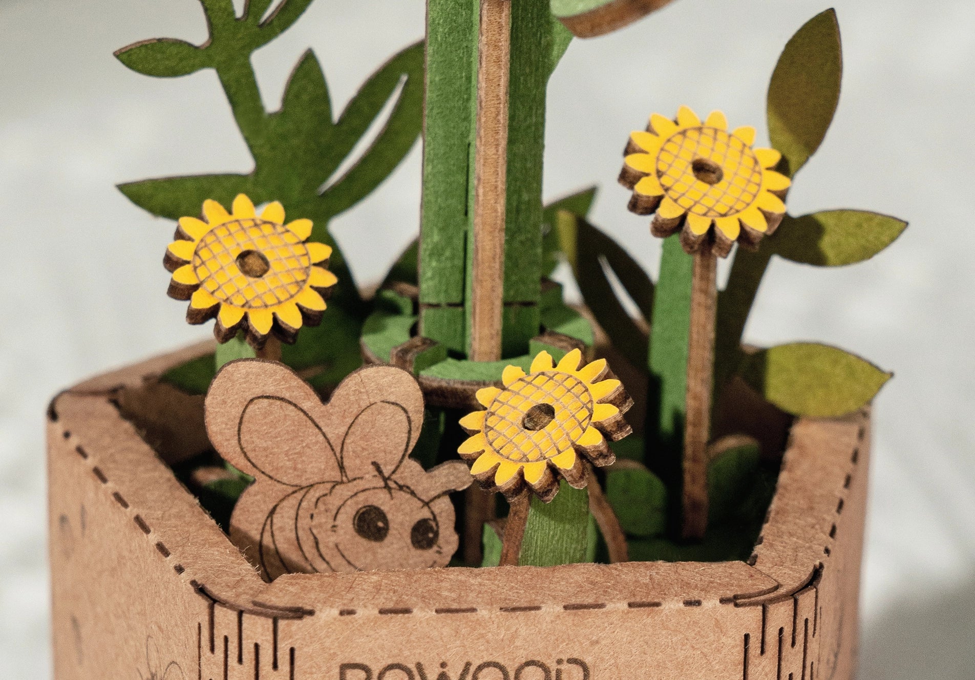Wooden sunflower DIY puzzle with flowers, bee, and plant details. Enhance your crafting skills with this unique gift from Robotime-Rolife. Dimensions: 5.9 x 5.3 x 2.1 in.