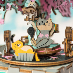 A DIY Music Box Cherry Blossom Tree, a whimsical wooden cat figurine on a tree. Wind up for a story-like melody, fostering concentration and decompression. From Strangecat Toys.