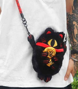 Person with Maneki Spider Cat Bag by ABAO, fashion accessory, cat, holding a black cat purse and a stuffed animal with a gold coin.