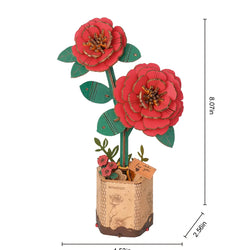 A wooden 3D puzzle of a red camellia flower in a pot. 96 wooden pieces, 30 minutes to assemble. Natural wood material, poetic and romantic floral design. Dimensions: 9.6 x 6.5 x 0.3 in.