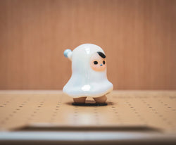 A blind box and art toy store: The Ghost figurine - The Original White by Pucky, a small vinyl toy with a white face on a table.