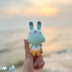 A hand holding a limited edition 10cm Sofy Vinyl toy named Summer Robin by Kotton Factory, embodying the essence of Strangecat Toys, a blind box and art toy store.