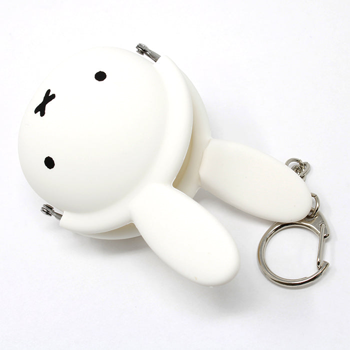 Miffy coin purse, a white plastic key chain with a rabbit face, ideal for daily use and travel. Dungaree fabric, adjustable shoulder belt, fits long wallet and iPhone Plus. Interior and zipper feature Miffy design.