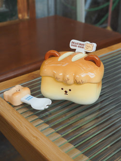 A plastic toy bread toaster with a cartoon face and a ceramic bread box with a cartoon face on it, along with a small plastic bear shaped object, resin material, 7cm height.