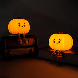 Emo Pumpkin Night Light featuring sad-faced glowing pumpkins on a radio. Silicone material, 800mAh battery, 9.5 hours high setting usage. From Strangecat Toys, a blind box and art toy store.