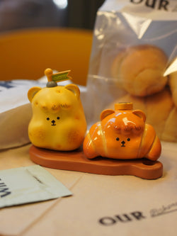 A resin toy titled Hanhan Bread by Unknown Island, measuring 9 * 5.5 * 6CM, shaped like a yellow croissant with small plastic toys.