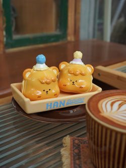 Hanhan Egg Puffs by Unknown Island - Preorder. Resin figurines of two ceramic bears on a plate with a cup of coffee. Ships Aug 2024.