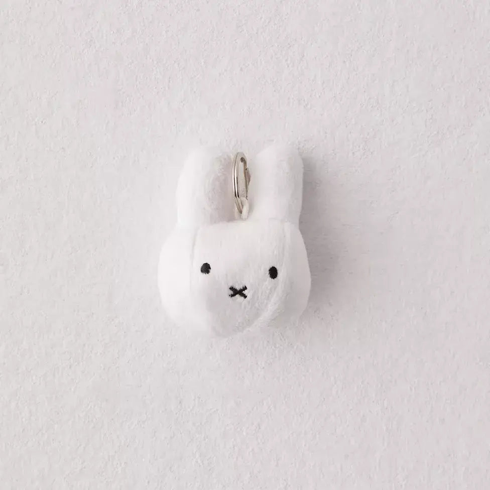 A Miffy Plush Keychain, a white stuffed animal with a face, and a bunny face key chain. Indoor design from the Netherlands. Size: 3.5x2.4x1.6, Weight: 0.03lb.