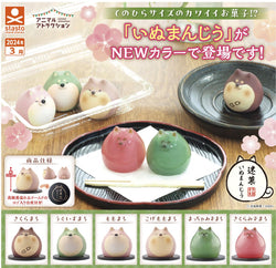 A group of round objects on a plate, including cat-shaped items and a toy, part of the Kaineko Shoji Meigashi Inumanjiusin Gacha Series - Preorder.