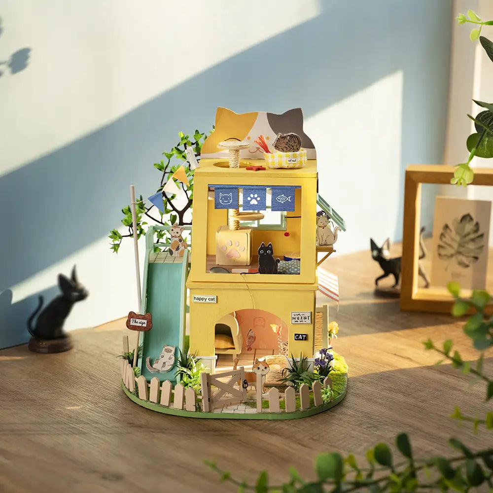 A DIY wooden dollhouse featuring a cat house theme from the Leisure Time series by Strangecat Toys. Detailed and spacious design with transparent PET sheet. Includes six tiny houses. Dimensions: 222*159*190mm.