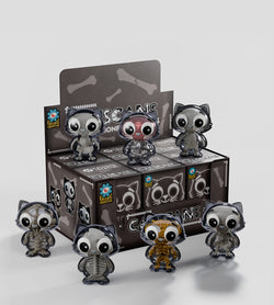 Catscans (Bare Bones) Blind Box featuring small toy figures, including a cartoon cat in a transparent case and a toy cat skeleton with large eyes.