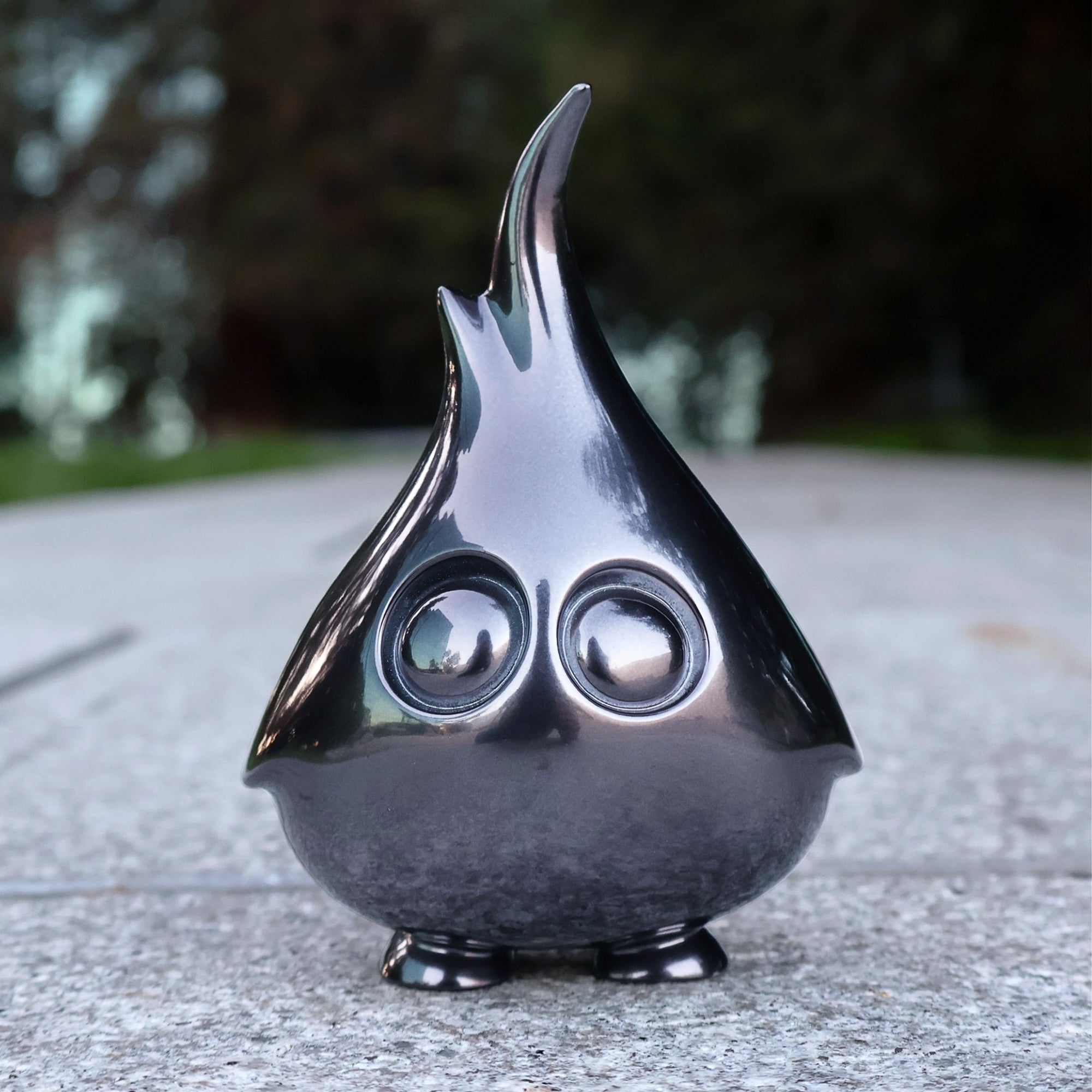 Mossy resin toy with round eyes on concrete surface, by Artiqfox X Riser13, limited edition of 75 pieces.