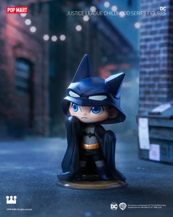 DC Justice League Childhood Blind Box Series Figures - Preorder: Toy figurine of a boy cartoon character in a garment, with a blue eye and a crown logo.