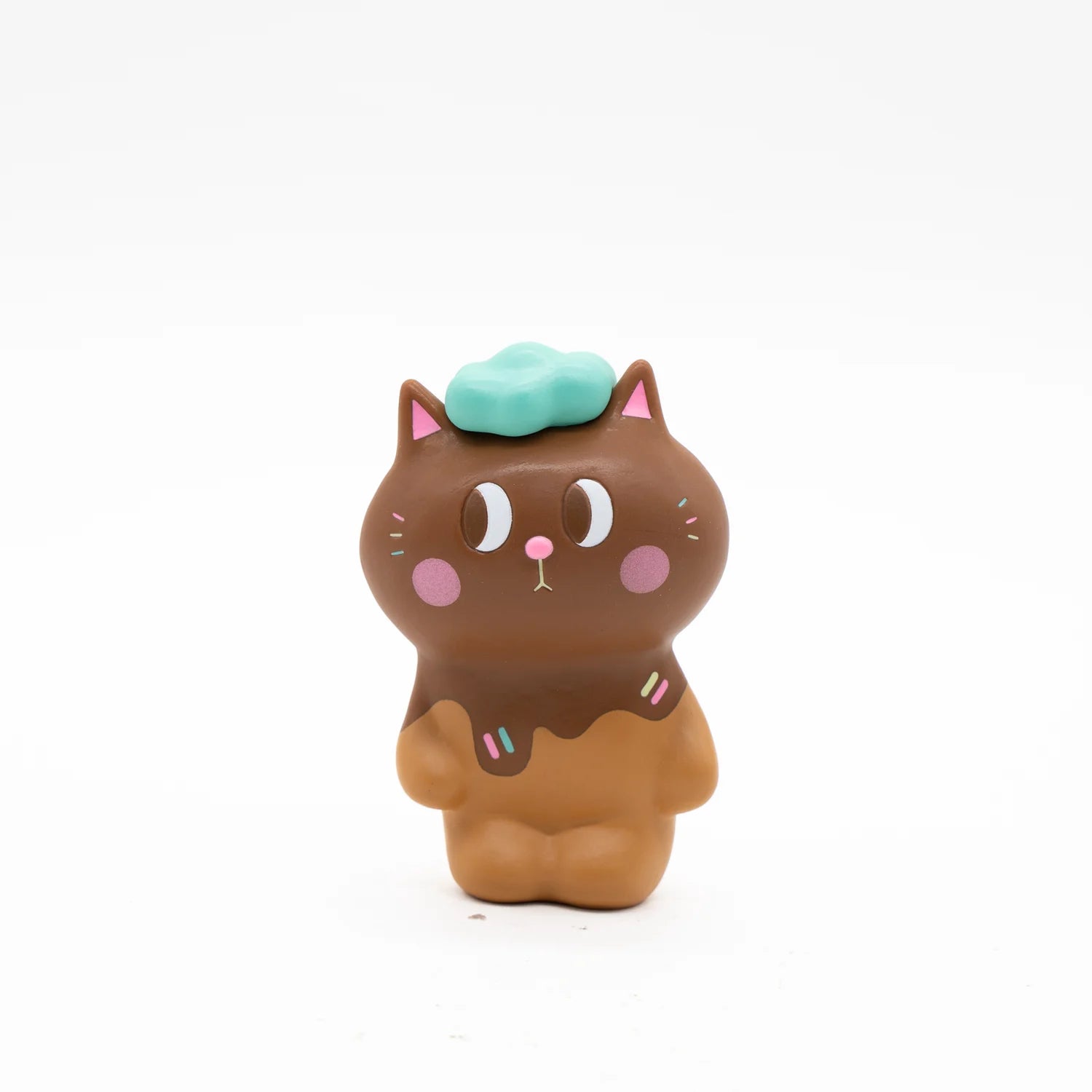 KIYO NEKO 'CHOCOLATE' EDITION: Toy cat with blue hat, pink circle, chocolate cake, and cloud-shaped object.