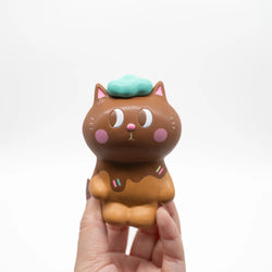 KIYO NEKO 'CHOCOLATE' EDITION toy cat held in hand, close-up of small toy, animal figure design by Helen Tam.