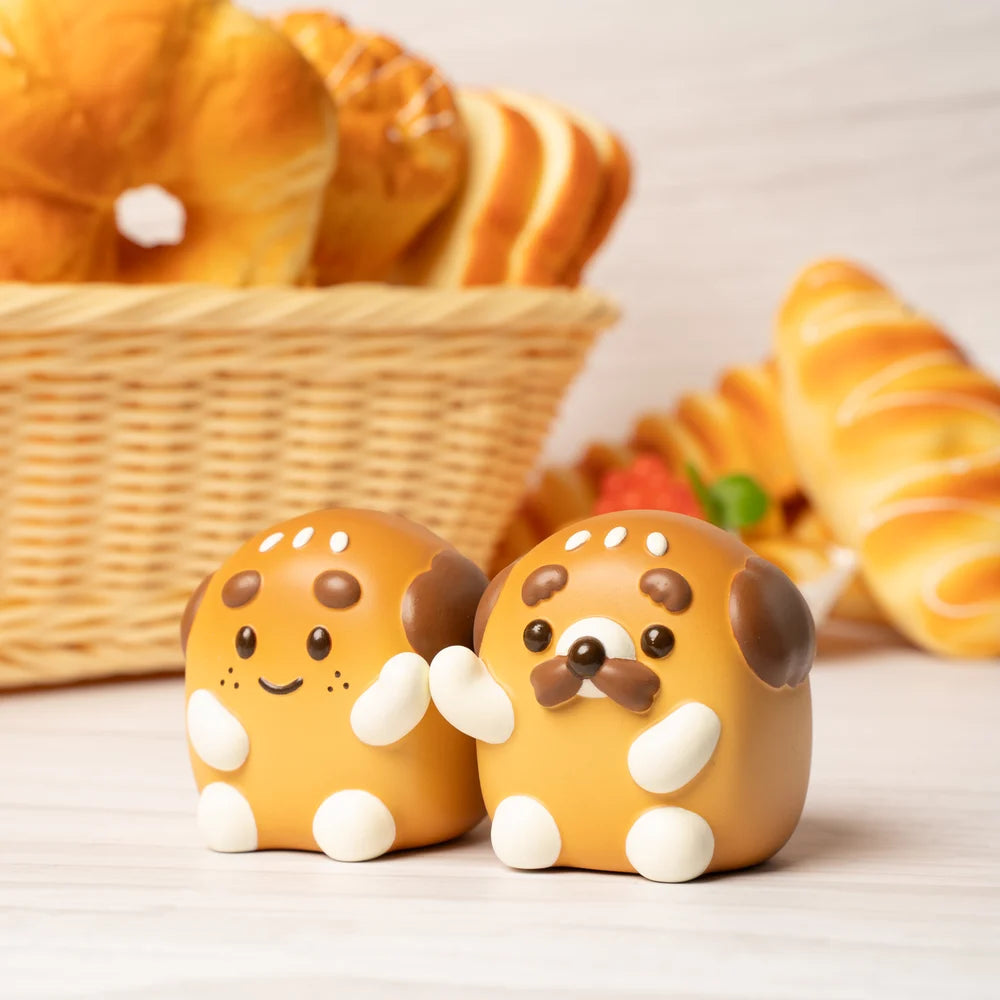 Two ceramic dogs next to a basket of pastries, including a toy and food close-ups, featuring CHUBBYMAN & MII PAN BREAD VINYL.