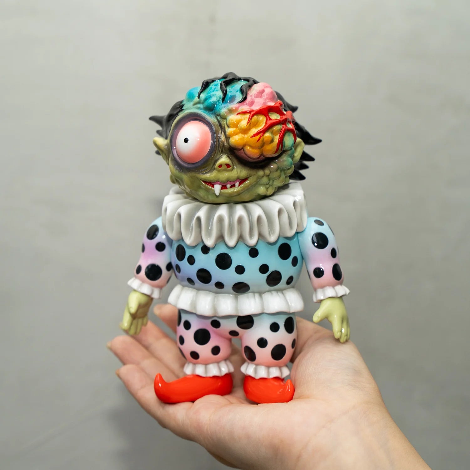 A hand holding a toy sculpture, KIBOJI TTF EDITION BY HIDESHI HINO, soft vinyl material, approximately 14cm tall.