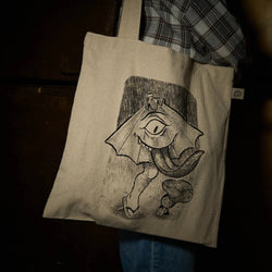 A person holding a bag with a bat drawing, plaid fabric, and shoe close-ups.