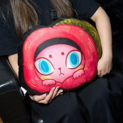 A person holding a pillow with a cartoon cat, part of the BADMEAW PLUSH CUSHION collection from Strangecat Toys.