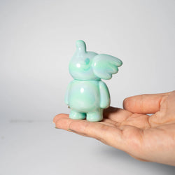 A hand holding ELFIE HERE I AM! 100% Tiffany Blue Edition, a 3-inch vinyl toy by Too Natthapong, featuring a minimalist, timeless design.