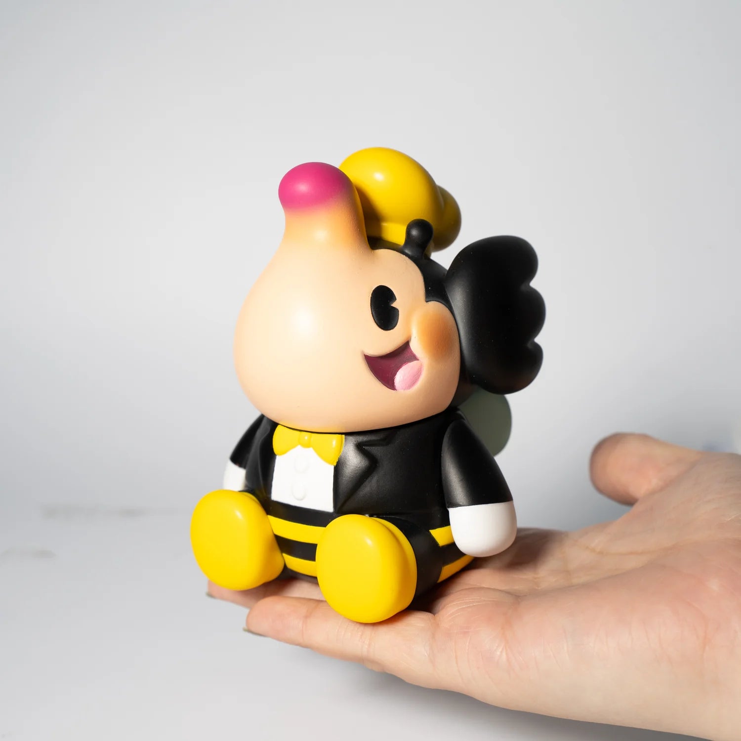 A hand holding the BUMBLE BEE ELFIE by Too Natthapong, a 3-inch soft vinyl toy from the Elfie series.