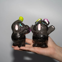 A hand holding two black glittery animal figurines from the ELFIE & NIMBUS YAWN GLITTER EDITION, preorder for July 2024.