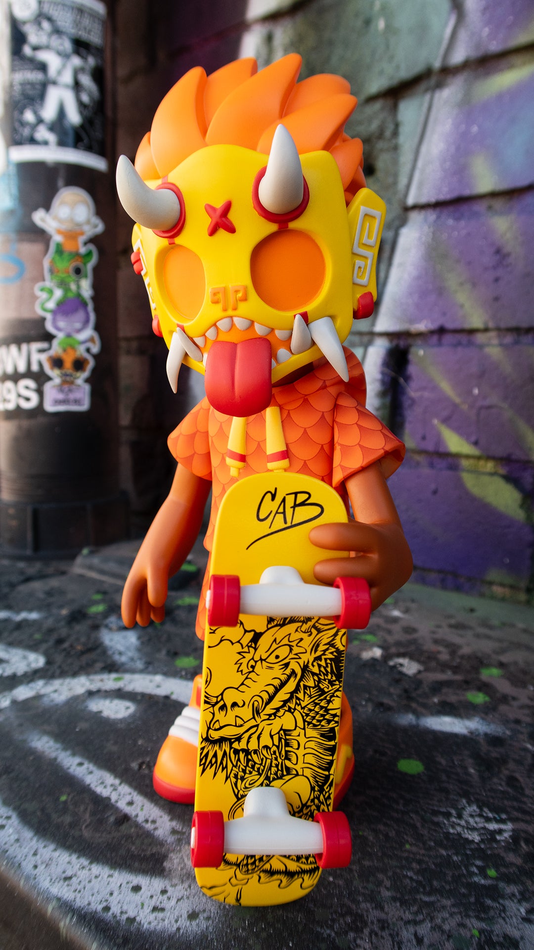 Toy figure with skateboard and yellow mask, skateboard with cartoon dragon, limited edition Thrasher Goblin - Cab Dragon Edition by Chris Dokebi x Steve Caballero.