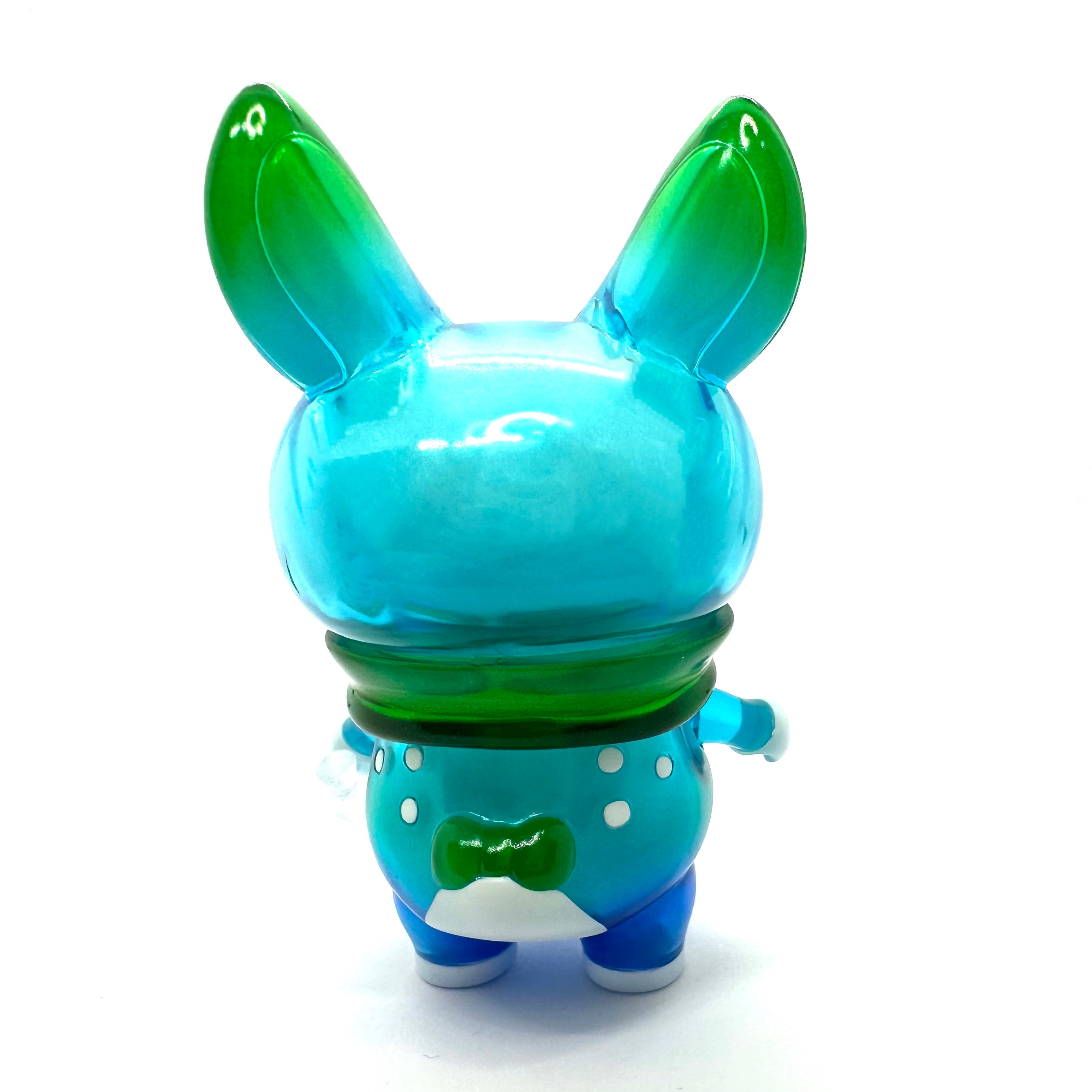 A blue and green toy animal figure, Momiji-chan Blue Pond by Asako Hashi, a unique vinyl character on an adventurous journey in Hokkaido.