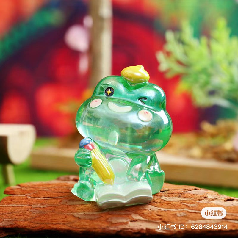 A blind box series featuring Autumn hidden by a frog figurine from the Little MI collection. Available at Strangecat Toys.