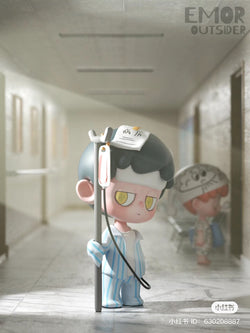 A blind box series featuring Emor - Outsider designs. Cartoon character in hospital setting holding a blood transfusion. Preorder now for June 2024 shipment.