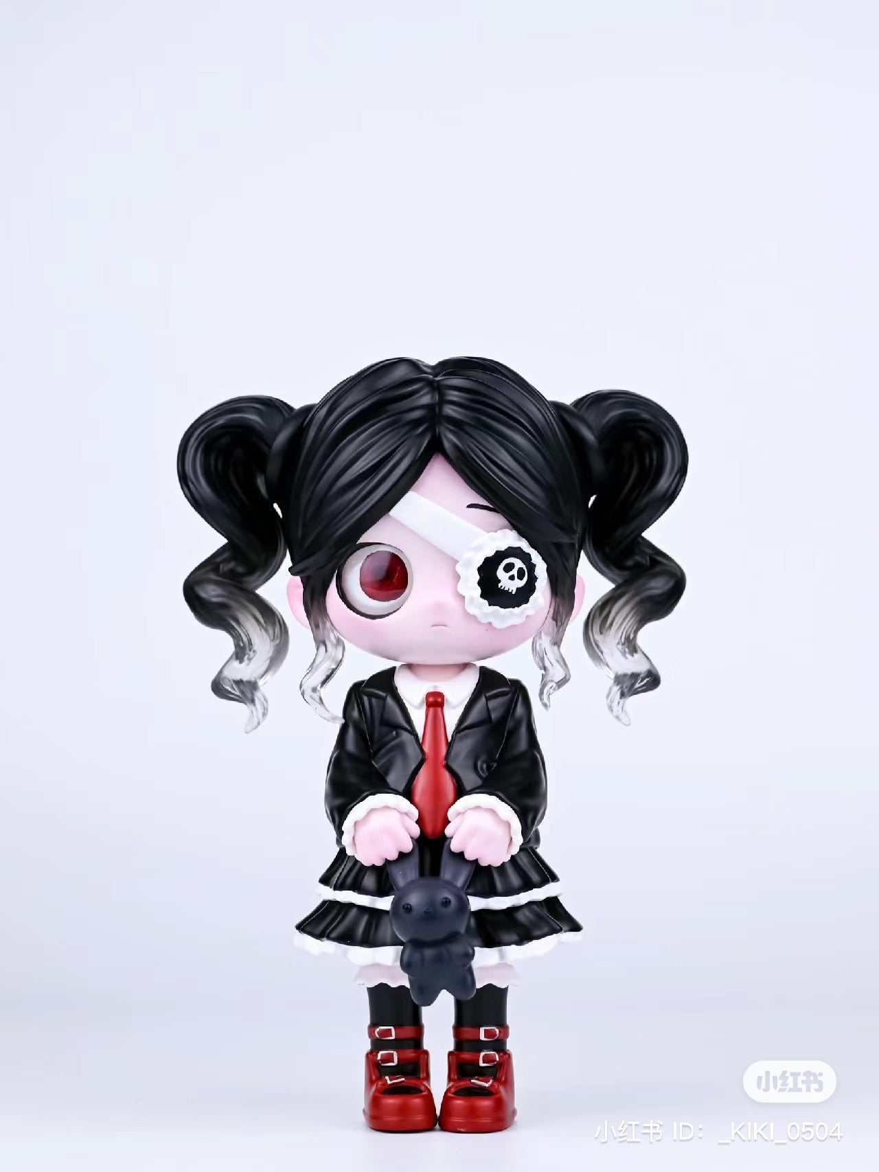 Kiki Girls 4.0 toy figurine: girl with pigtails, red tie, and eye patch, holding a rabbit. Resin/PVC, 11cm.